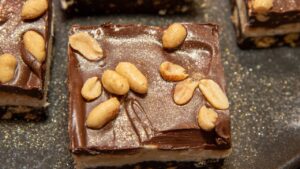 Barras Nanaimo onde o chocolate encontra o amendoim salgado e cria um contraste irresistível em camadas