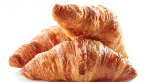 Croissant caseiro com camadas que se abrem como páginas de um livro quente saído do forno