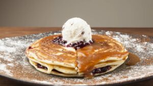 Panqueca macia combinada com sorvete cremoso, finalizada com calda brilhante