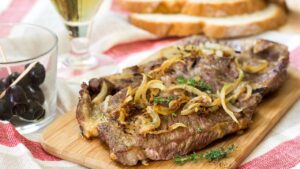 Aqui o bife ganha vida: suculento, cheio de sabor, e coberto por cebolas macias como seda quente