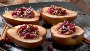 Peras assadas que amaciam no forno enquanto o mel carameliza e as cranberries trazem um brilho azedinho