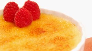 Crème brûlée com casquinha de açúcar que quebra como vidro fino sob a primeira colher