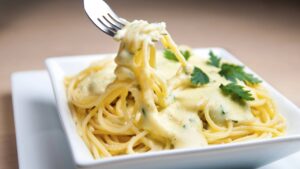 Molho branco aveludado, massa fumegante e um perfume amanteigado que anuncia prazer imediato