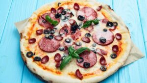 Pizza de calabresa de liquidificador simples com cebola e muçarela