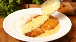 O contraste do empanado crocante com o molho cremoso faz esse prato inesquecível