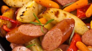 Assadas juntas Linguiça e Batatas criam um prato simples para um Jantar especial