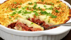 Escondidinho de Carne Seca Purê cremoso envolvendo carne desfiada bem temperado